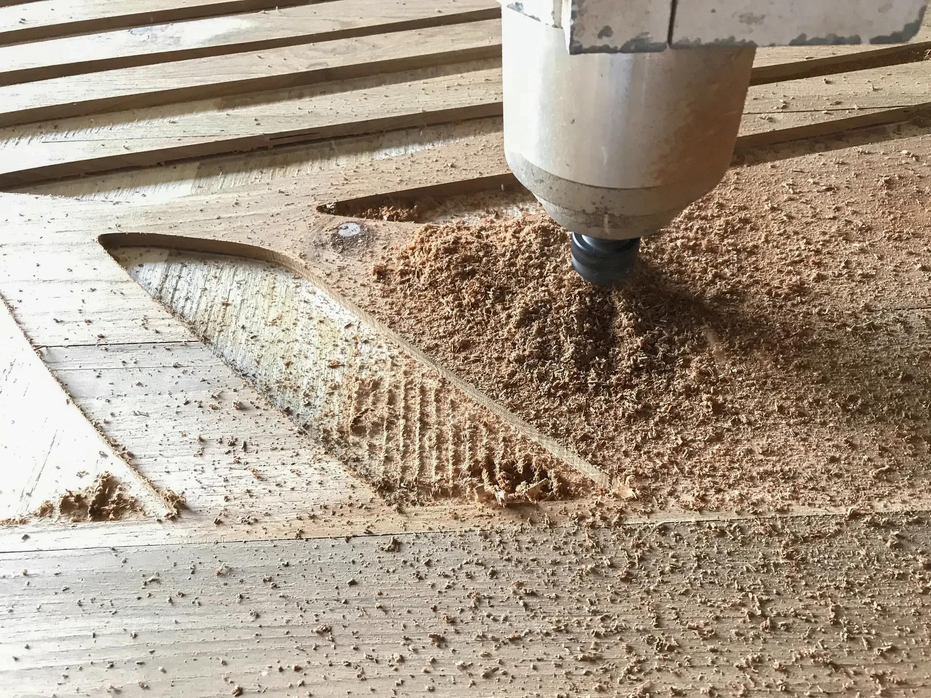 Corte y maquinado con router CNC en tablero de madera, con viruta del desbaste